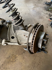 Includes everything shown, a – arms, hubs, spindles, and rotor, as well as the strut assembly